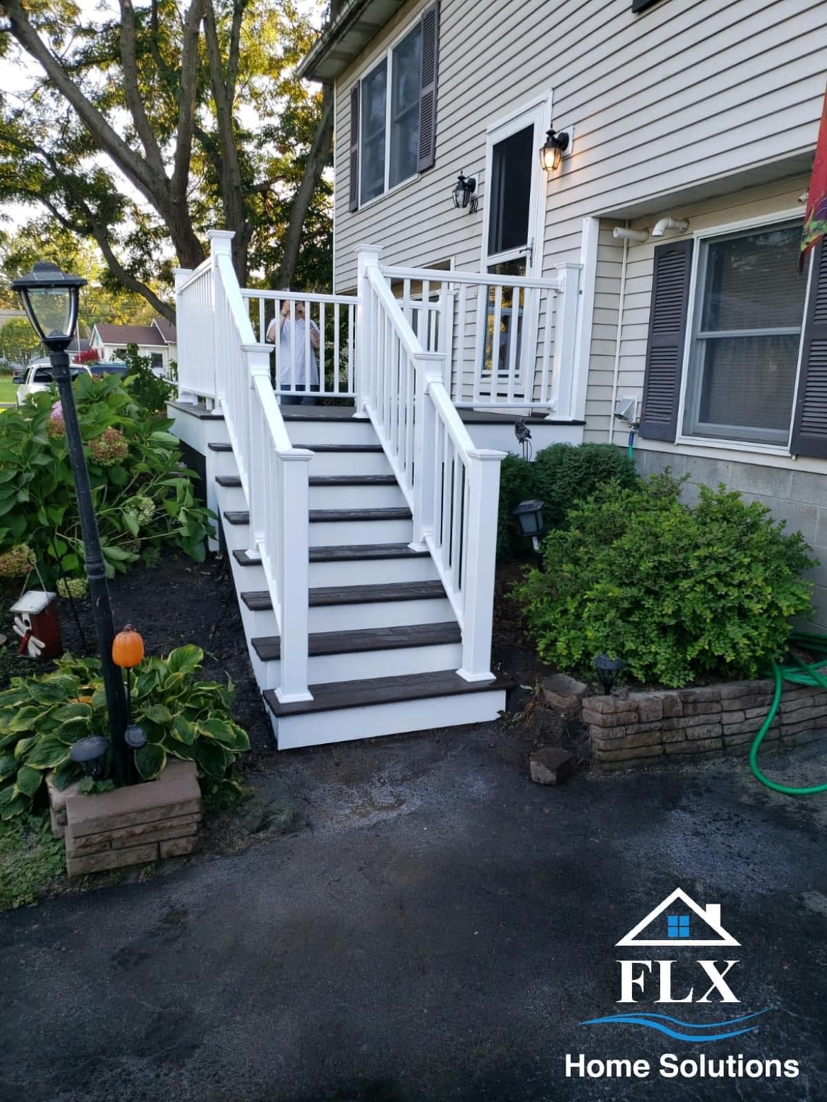 White railed porch with gray composite steps leading to home entrance
