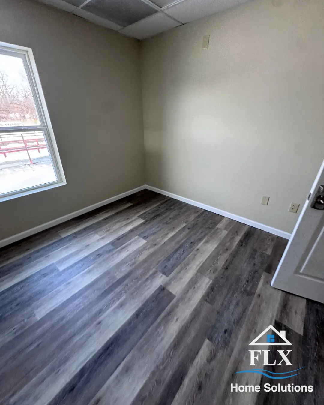 Renovated room with window and dark-toned vinyl plank flooring