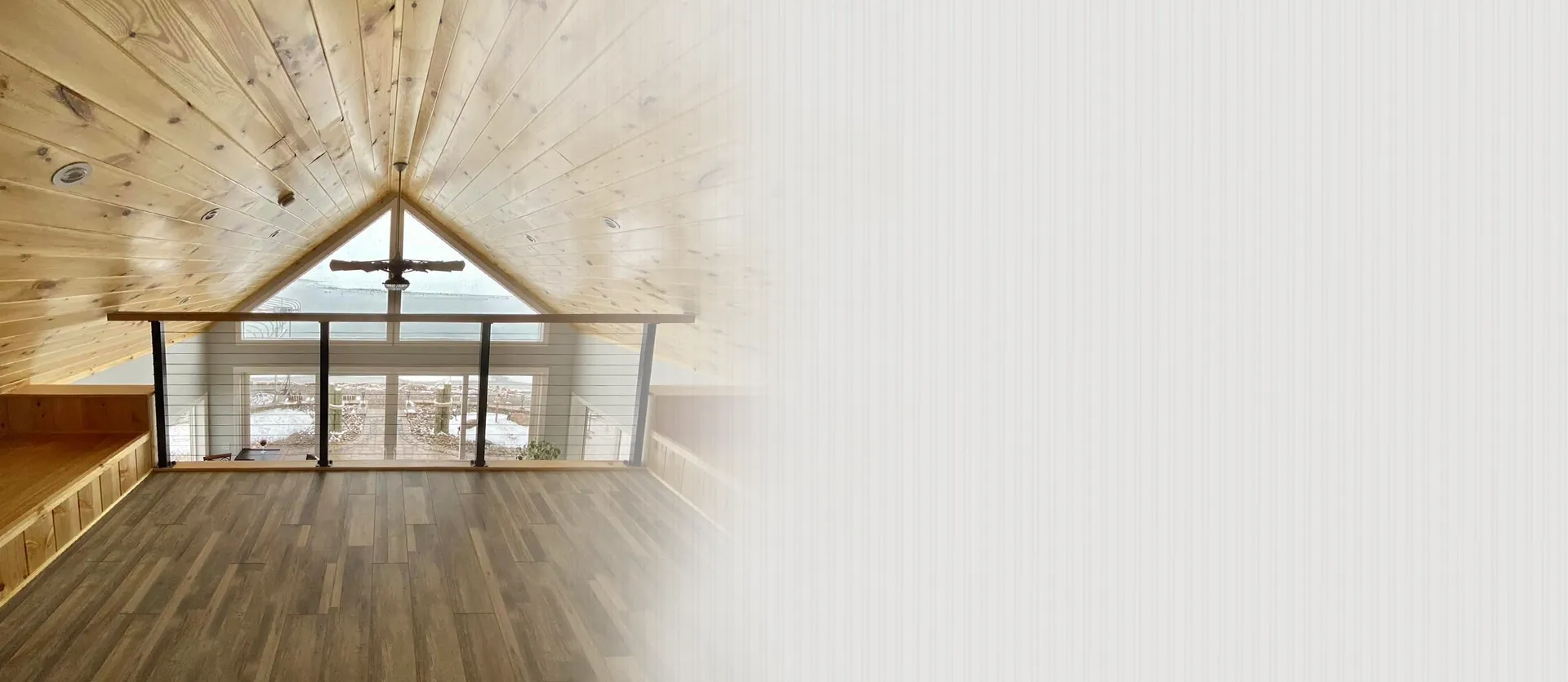 Modern loft interior with vaulted pine wood ceiling and hardwood floors